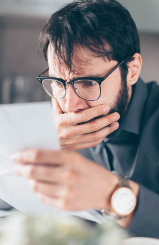 Uomo che guarda i conti preoccupato